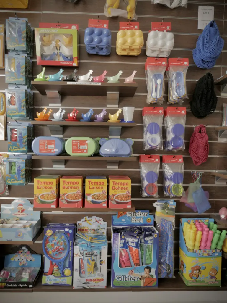 Wand mit Ostprodukten: Eierboxen, Hühner-Eierbecher, Brotdosen, Einkaufsnetze, Tempo-Erbsen und -Linsen sowie Spielzeug für draußen